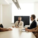 a group of people sitting at the table at a business meeting