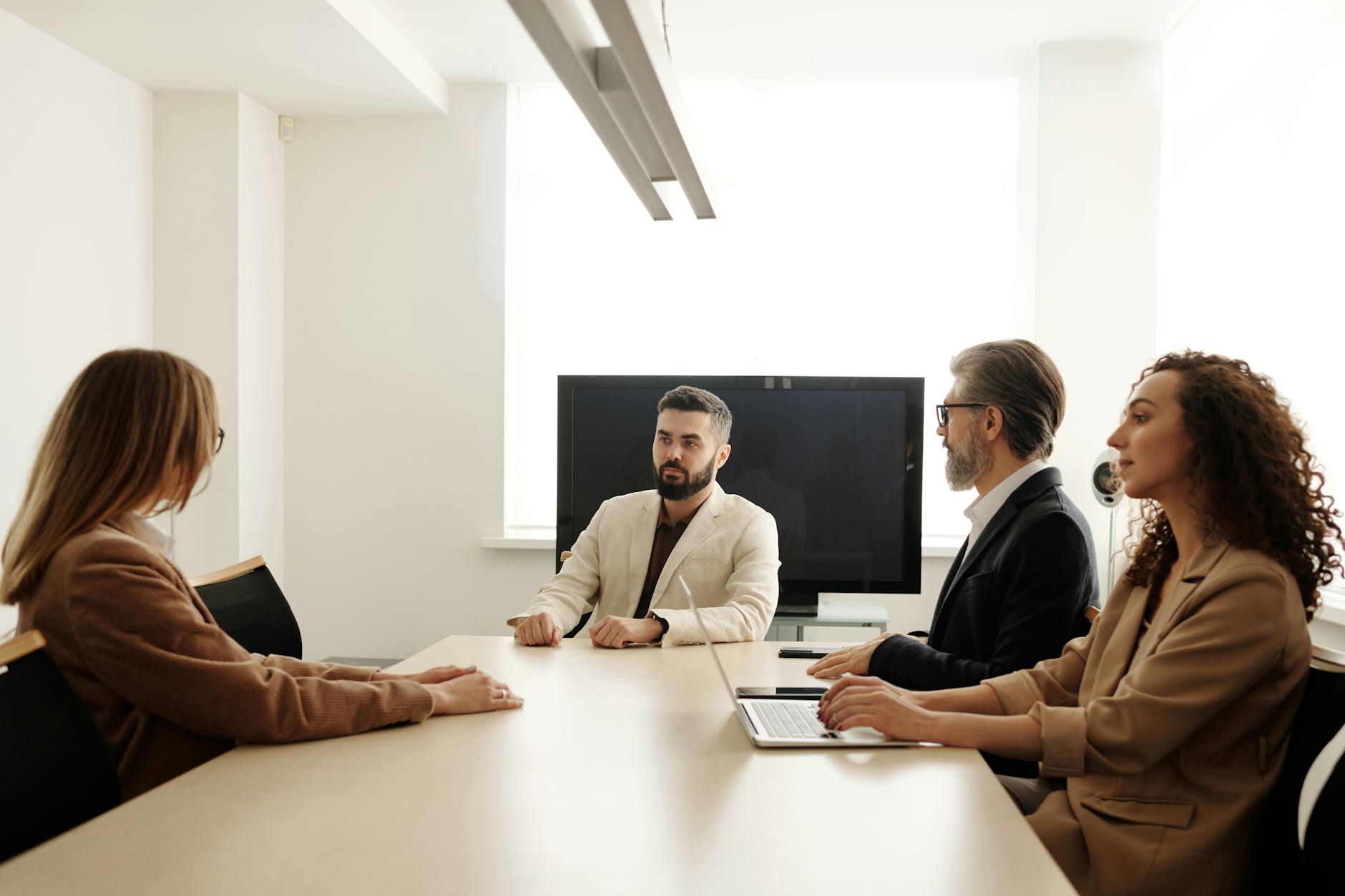 a group of people sitting at the table at a business meeting